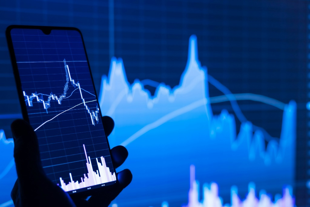 A smartphone displaying a cryptocurrency trading chart with a rising trend line.