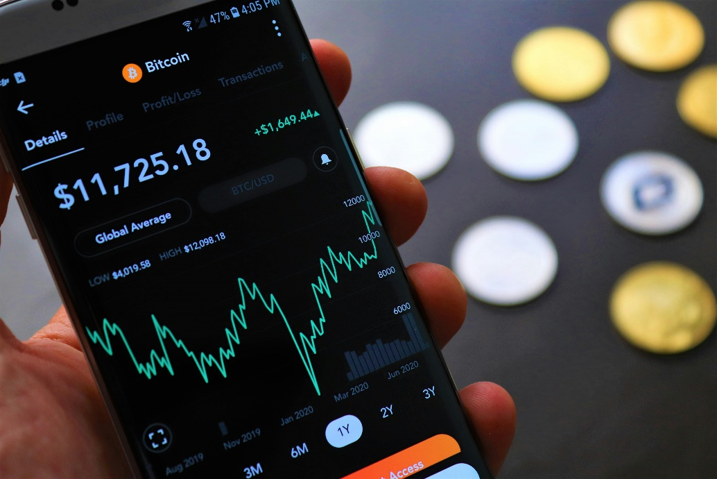  A close-up of a smartphone screen displaying a Bitcoin price chart and account details.