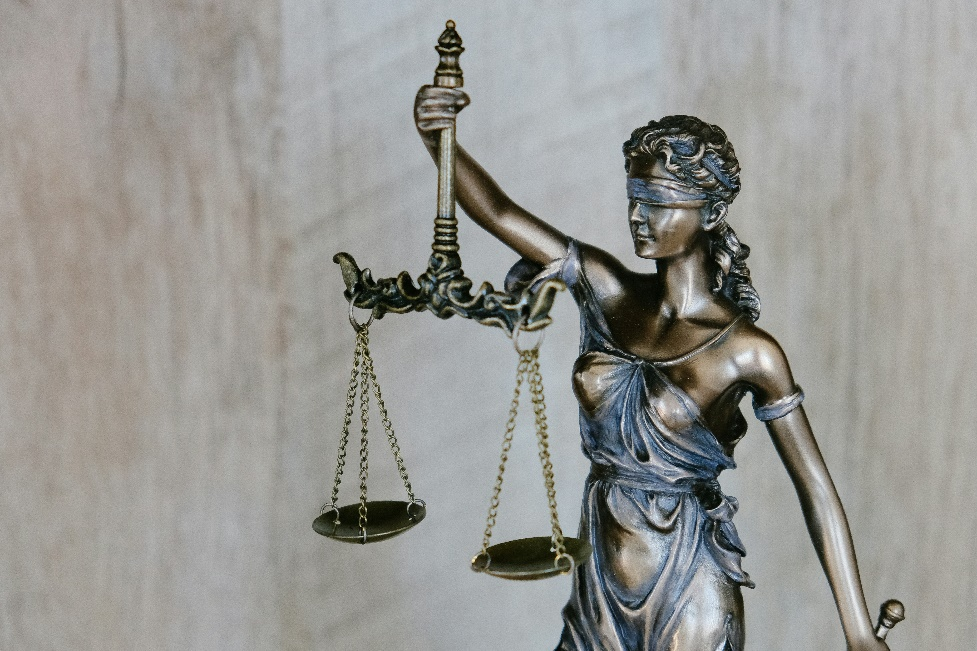 A statue of Lady Justice holding a scale in one hand and a sword in the other, with a blindfold over her eyes.