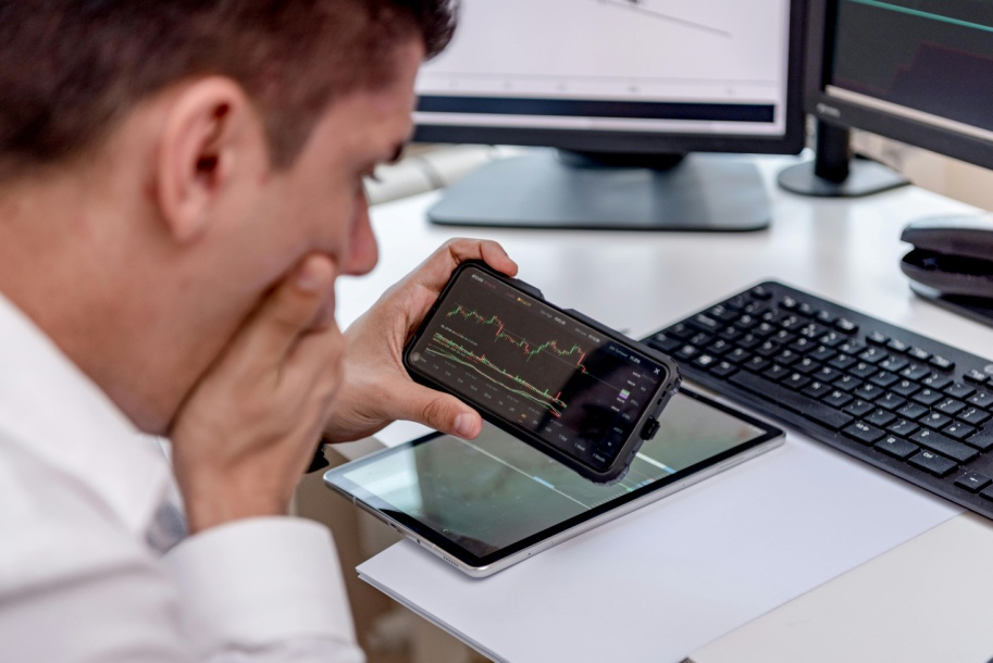 Businessman using AI-powered crypto trading app on smartphone