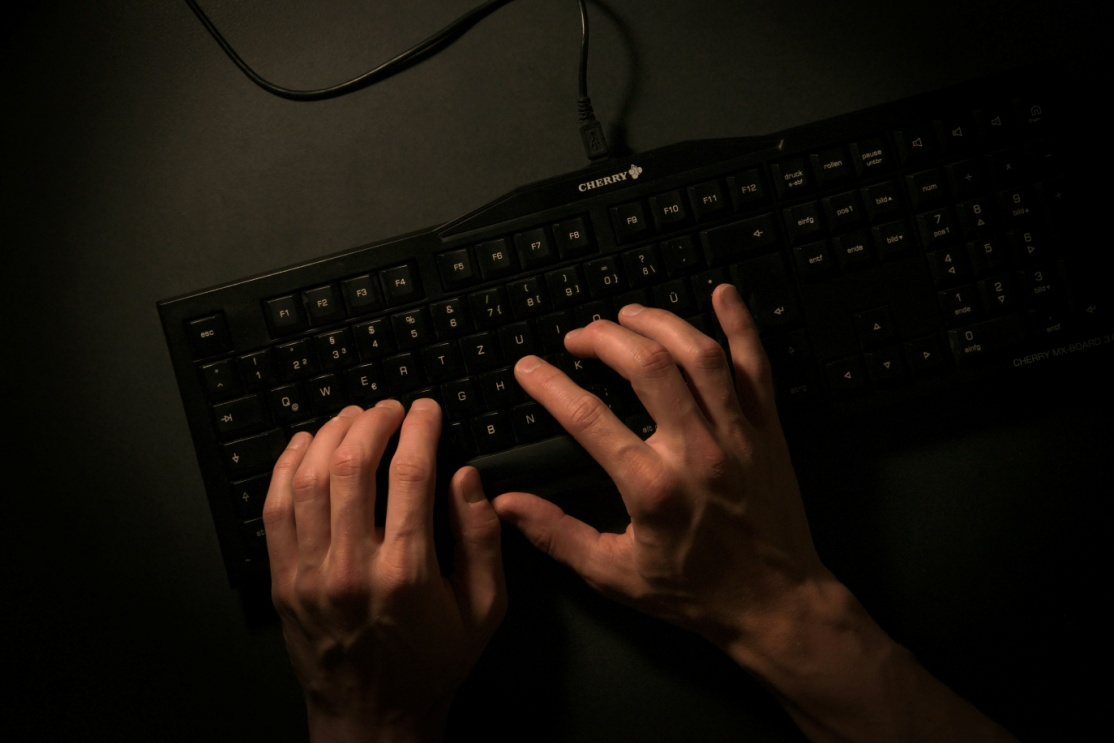 Person typing on a black keyboard