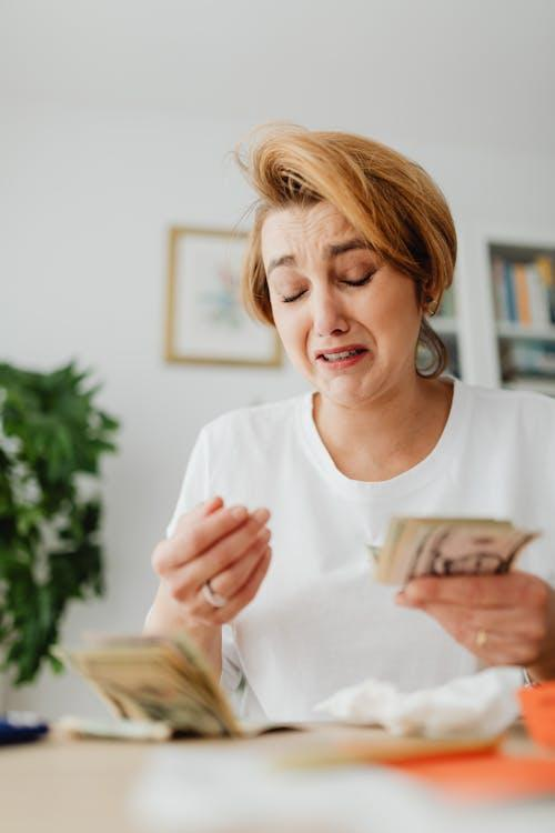 woman counting money and crying
