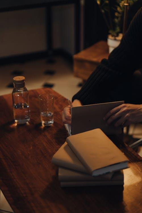 person in black long sleeve shirt holding white book