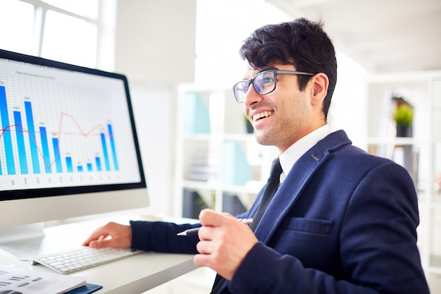 man in formal dressing looking at a computer in the office