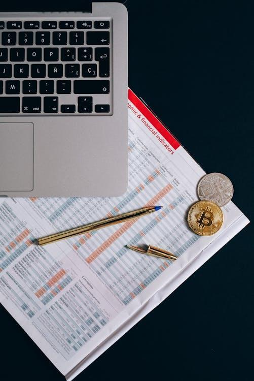 silver and gold coins near the laptop