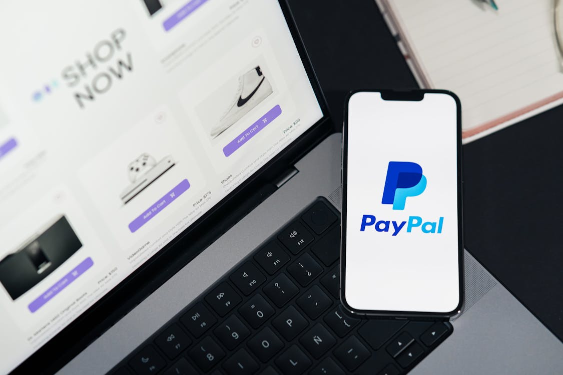 A laptop screen displaying the PayPal logo during a mobile payment process.