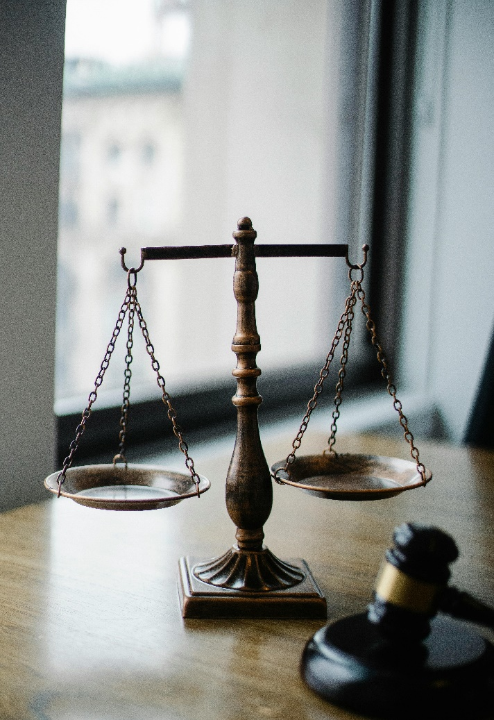 Judgement scale and gavel on a wooden desk in a judge's office