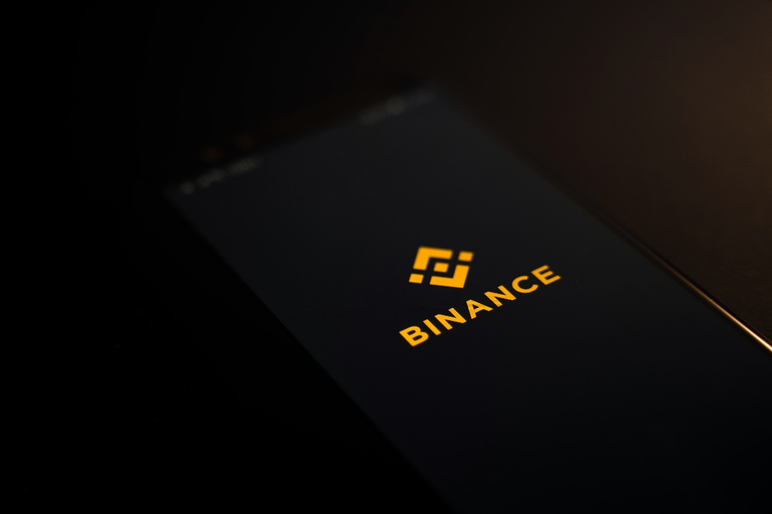 A smartphone screen in dark mode, displaying the Binance cryptocurrency exchange logo.