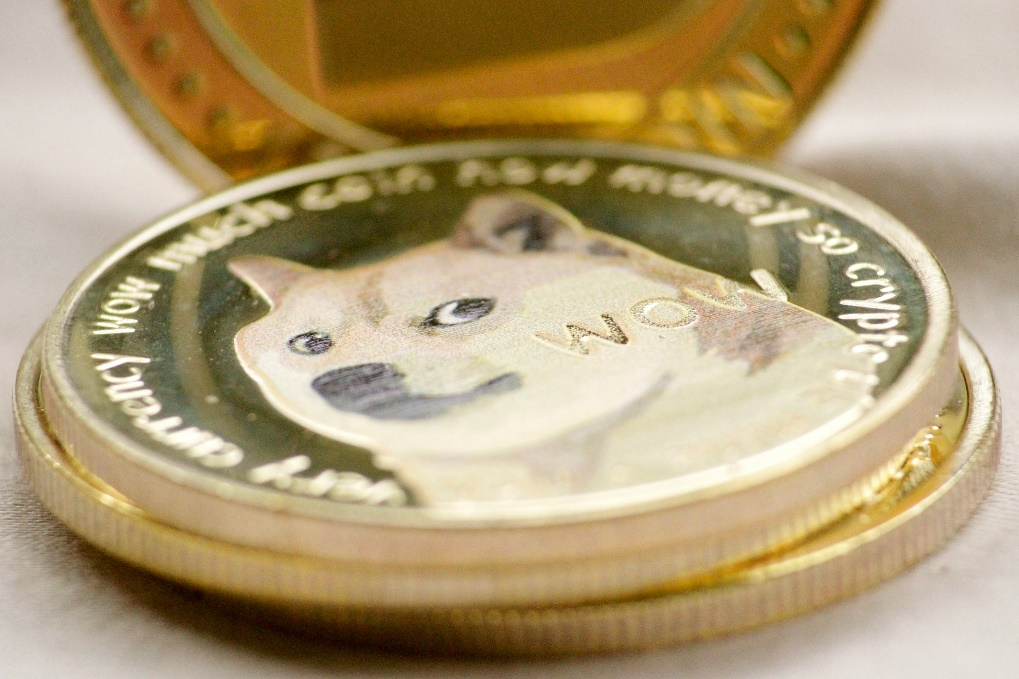 A Dogecoin cryptocurrency coin with the Doge meme dog on its face.