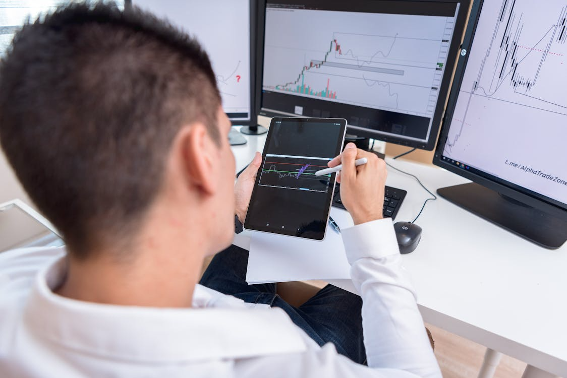 a-man-looking-at-the-graphs-on-black-tablet