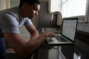 Investor reviewing cryptocurrency market charts on a laptop while analyzing digital asset market behavior and token performance trends.