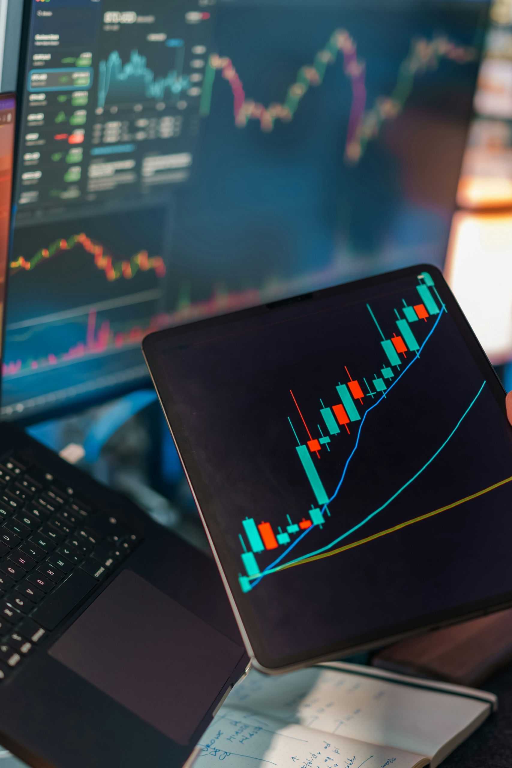 Investor analyzing cryptocurrency price charts on tablet and monitors while evaluating long-term market trends in digital asset markets.